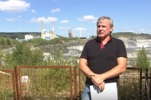 Karel Marek, z&aacute;stupce Spolku Herout, s prachovickou cement&aacute;rnou na pozad&iacute;.